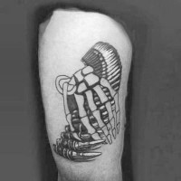 Tatuaje en el muslo,  mano de esqueleto con balas