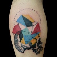 Tatuaje en la pierna,
cráneo humano con  figura geométrica de varios colores