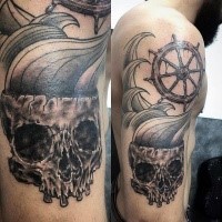 Interesting combined upper arm tattoo of human skull with ships steering wheel