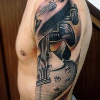 Interesting designed and colored big cool guitar tattoo on sleeve area