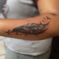 particolare inchiostro nero piuma di uccelli tatuaggio su braccio