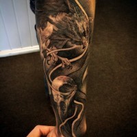 Interesting looking black and white forearm tattoo of flying eagle and human skull