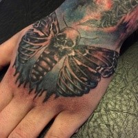 Interesting looking colored hand tattoo of bone butterfly