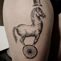 Interessantes gemaltes großes schwarzes Pferd mit Rad und Zylinderhut Tattoo am Oberschenkel