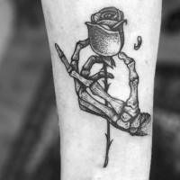Tatuaje en el antebrazo, mano esqueletica que lleva una rosa