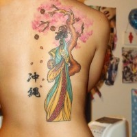 Tatuaje en la espalda,
chica china cerca de un árbol