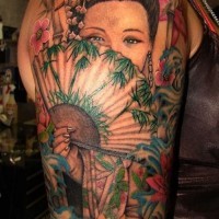 Japanese geisha with a fan of tattoos on arm