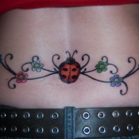 Ladybug and flowers tattoo on lower back