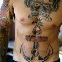 Large black ink chest and belly tattoo of king crown with wings, lettering and big anchor
