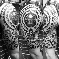 Large black ink Polynesian style tattoo on shoulder