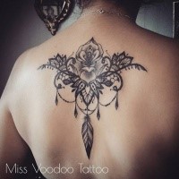 Large blackwork style upper back tattoo of large flower by Caro Voodoo
