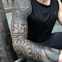 Large blackwork style whole sleeve tattoo of creative floral ornaments