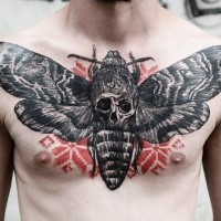 Large engraving style very detailed butterfly tattoo on chest with human skull