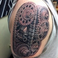 Large realism style engine gearwheels with chain tattoo on shoulder