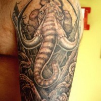 Large wonderful gray-ink mammoth tattoo on upper arm