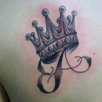 lettera e corona tatuaggio sulla scapola