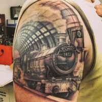 Life like  detailed upper arm tattoo of vintage train and lettering