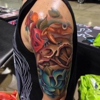 Lifelike beautiful looking shoulder tattoo of birds skull with frog and flowers