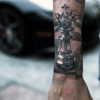 Lifelike colored hand tattoo of king chess figure