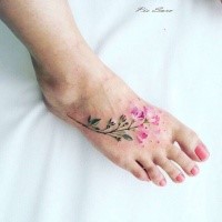 Lifelike sweet looking colored foot tattoo of small flower branch