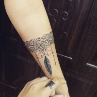 Linework style black ink forearm tattoo of floral ornament with feather