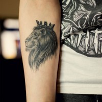 Lion face tattoo with crown on head