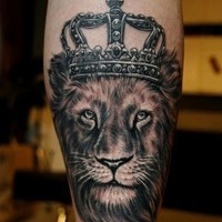 Lion head in a crown tattoo on arm