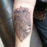 Lion in royal crown forearm tattoo