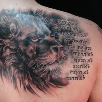 Lion head with hebrew writings tattoo
