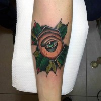 Little 3D like colored mystical eye in geometrical figure tattoo on forearm stylized with leaves