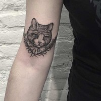 Little 3D like natural looking funny cat tattoo on arm with leaves