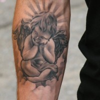 Little angel seated on cloud tattoo on arm