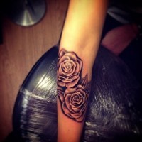 Little black and white natural looking rose flowers forearm tattoo