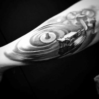 Kleines schwarzes und weißes altes Vinyl-Schallplatten Player Tattoo am Arm