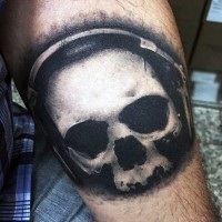 Little black and white skull with head set tattoo on arm