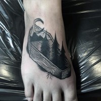 Little black and white wooden coffin with moon and trees tattoo on foot