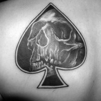 Little black ink spades symbol stylized with skull tattoo on shoulder