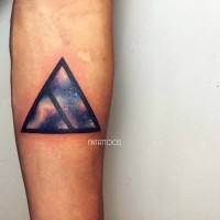 Tatuaje en el antebrazo, triangulo de líneas negras con cosmos en él