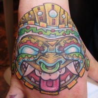 Tatuaje en la mano,  cara tribal de varios colores