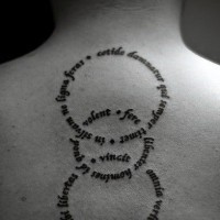 Tatuaje en la espalda, inscripciones elegantes en formas de circulos