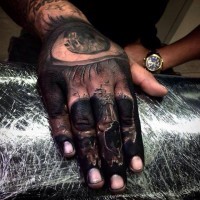 Kleines farbiges mystisches Schädel Tattoo an der Hand mit dem menschlichen Auge