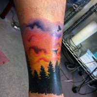 piccolo colorato alba sopra foreste tatuaggio su gamba