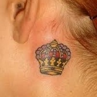 Tatuaje de corona multicolor detrás de la oreja