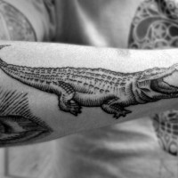 Tatuaje en el antebrazo,
caimán sencillo de tinta negra