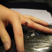 Kleiner Marienkäfer Tattoo am Finger