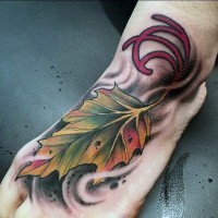 Kleines mehrfarbiges Blatt mit dem Symbol Tattoo am Fuß