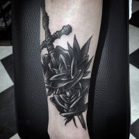 Kleiner schön gestalteter schwarzer und weißer Dolch mit Blumen Tattoo am Bein