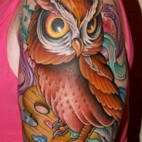Little nice looking colorful owl tattoo on shoulder with watercolor paints