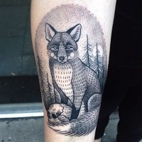 Little oval shaped black ink tattoo on forearm stylized with fox and human skull