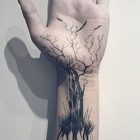 Tatuaje en la muñeca, árbol con raíces largas y ramas con aves, tinta negra